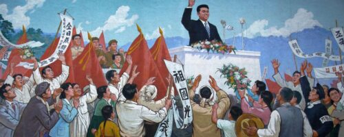 Pjongjang, uczennice kłaniają się muralowi z podobizną Kim Ir-Sena przed rozpoczęciem sprzątania chodnika fot. Wong Maye-E/AP/East News