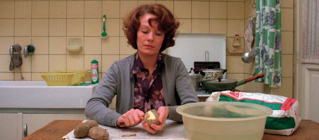 Kobieta obiera ziemniak. Kadr z filmu Jeanne Dielman